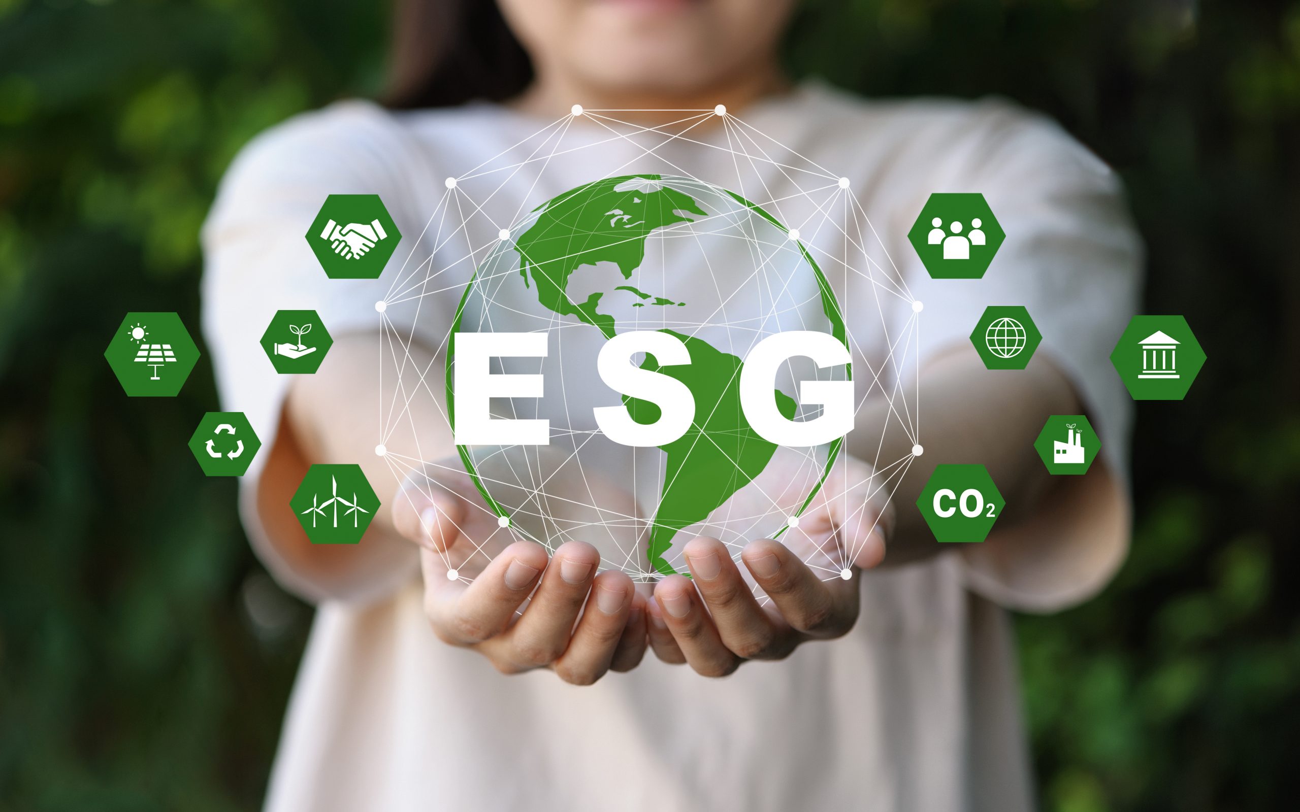 ESG icon concept in the hand for environmental, social, and governance in sustainable and ethical business on the Network connection on a green background.